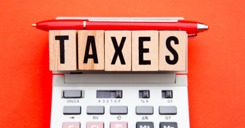 the word "taxes" spelled out with scrabble tiles